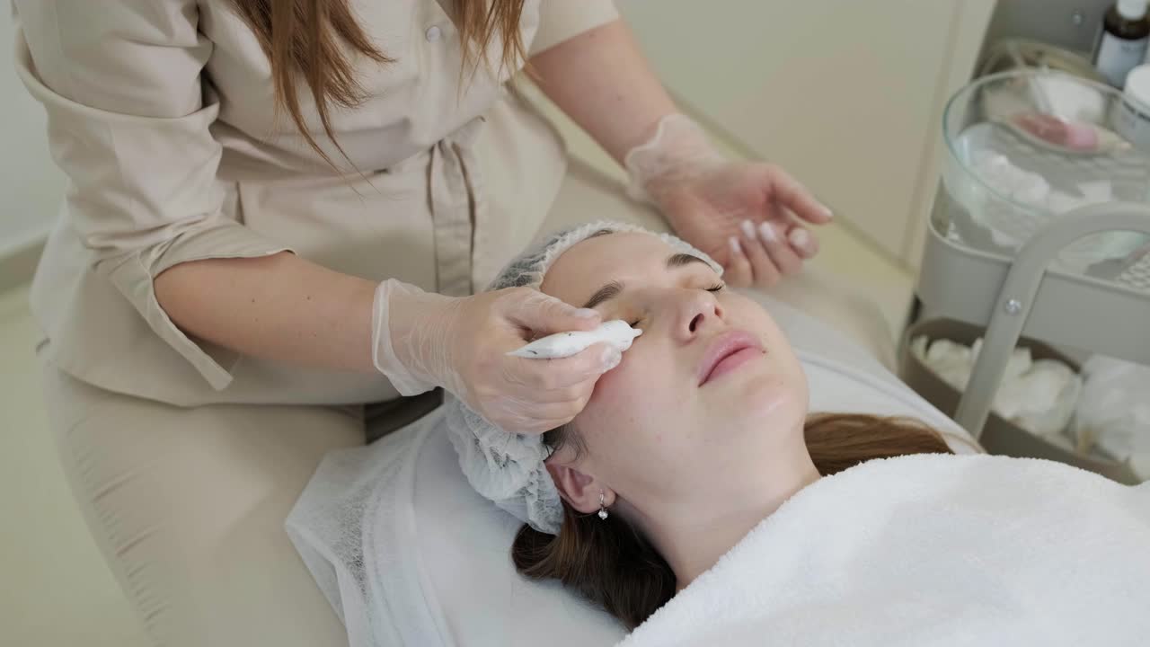 미용 전문가가 얼굴 치료와 얼굴 마스크를 적용합니다.