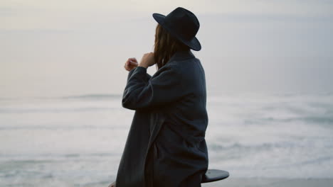 Girl-sitting-dramatic-seascape-enjoying-ocean-waves.-Woman-posing-at-seashore