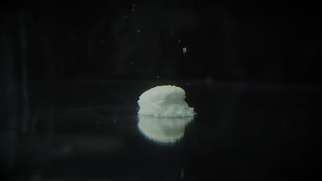 el lapso de tiempo de la cápsula gris y blanca de la píldora se disuelve en agua como una cápsula de medicamento en descomposición en el estómago e intestinos