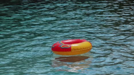 red and yellow inflatable pool ring floating in water