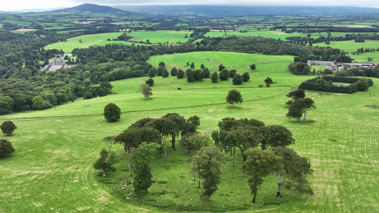 aerial volando sobre el fuerte de las hadas en las exuberantes tierras de cultivo waterford en el tiempo de la cosecha