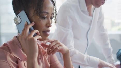 Diversos-Empresarios-Trabajando-Y-Hablando-Por-Teléfono-Inteligente-En-Una-Oficina-Creativa