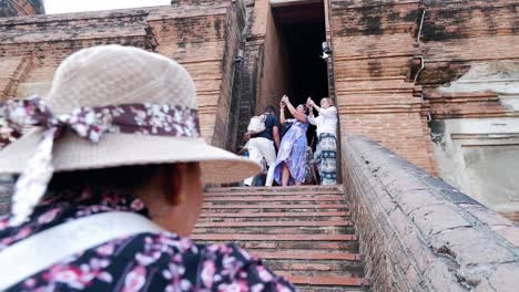 people ascending ancient temple stairs together