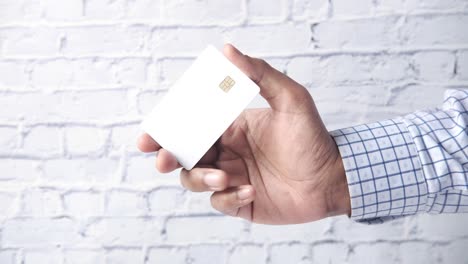 hand holding a blank white credit card