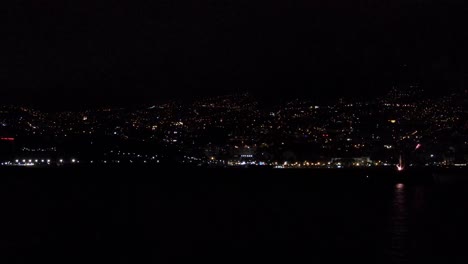 Fireworks-over-the-ocean-coast-at-the-Funchal-city-in-Portugal,-Madeira