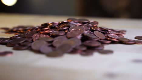 Pile-of-cent-coins-on-wooden-table-with-dark-background-and-bokee