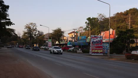 vehicles moving through a bustling street at dusk