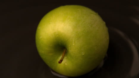 Green-apple-spinning-on-wet-surface