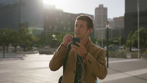 Retrato-De-Un-Joven-Y-Apuesto-Hombre-De-Negocios-Caucásico-Que-Usa-Auriculares-Haciendo-Llamadas-Telefónicas-Usando-Un-Teléfono-Inteligente-En-Un-Hombre-Urbano-De-La-Ciudad-Llamando-Por-Teléfono-Móvil