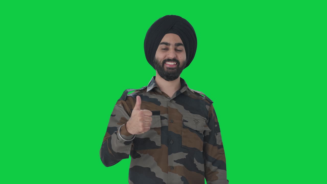 feliz sikh hombre del ejército indio mostrando pulgares hacia arriba pantalla verde