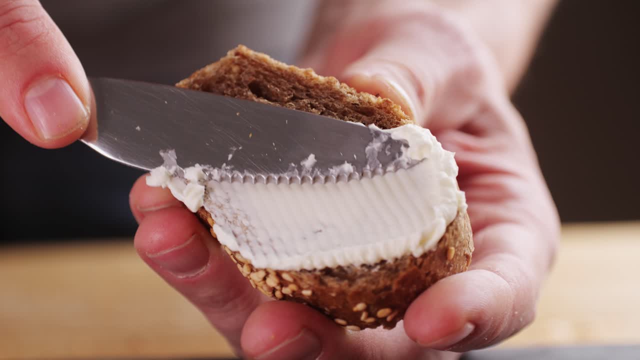 Butter being spread on a slice of whole wheat bread