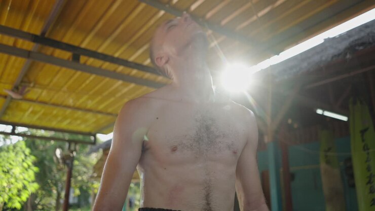 Sweaty man exercising in an open-air gym