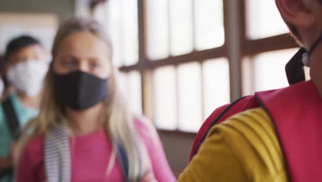 Grupo-De-Niños-Con-Máscaras-Faciales-Haciendo-Cola-En-Clase