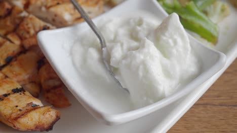 close up of grilled chicken with tzatziki sauce