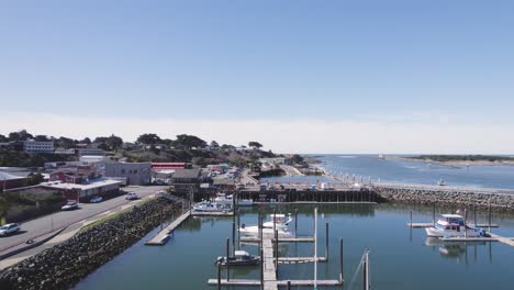 incredible 4k rising aerial over boat harbor and parking lot revealing ocean horizon of bandon, oregon