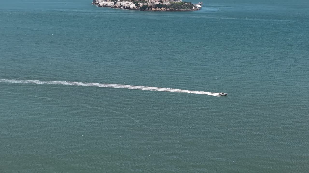 Aerial View of Alcatraz Island and Prison Buildings, Speedboat in San Francisco Bay, California USA, Revealing Drone Shot