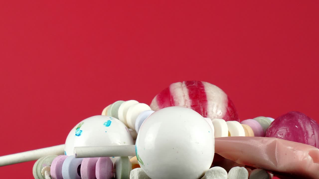 aislado contra un brillante fondo rojo cereza, una tentadora porción de dulces para niños gira lentamente