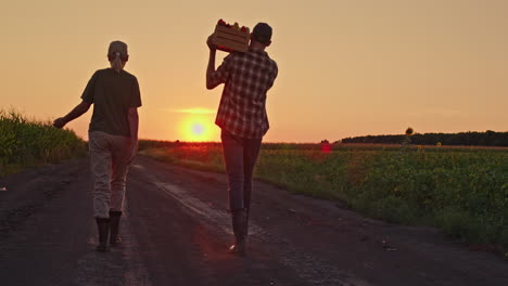 farmers carrying vegetables at sunset