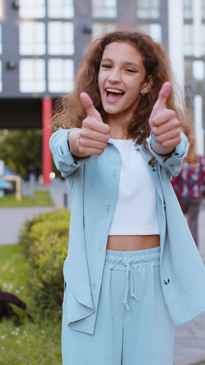 Happy girl showing thumbs up like sign positive something good positive feedback in city street