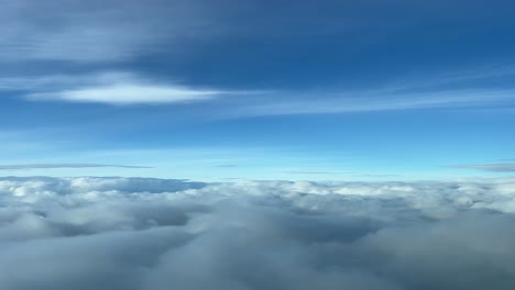 cold winter sky full of snowy clouds at 10000m high, recorded from a jet cockpit