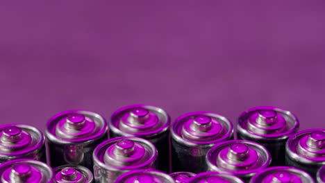 silver batteries aa and aaa in neon light close-up. double-a battery is a standard size single cell cylindrical dry battery. batteries are common in portable electronic devices. an aa battery is composed of a single electrochemical cell that may be either a primary battery or a rechargeable battery.