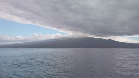 Gimbal-wide-panning-shot-of-Haleakala-volcano-from-a-boat-on-the-ocean-near-Molokini-Crater-in-Maui,-Hawai'i