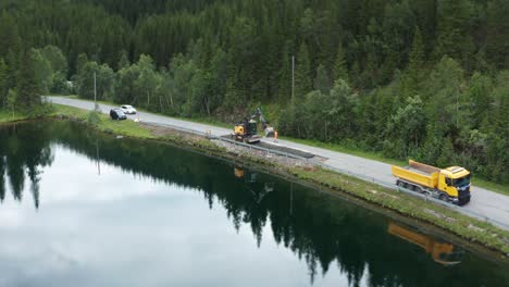 Reparación-De-Calzadas-En-Las-Zonas-Rurales-De-Noruega,-En-La-Estrecha-Carretera-Que-Bordea-El-Río