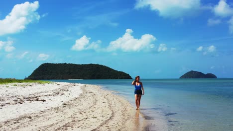 an excited teenage girl with a smile on her face enjoying a walk along the white sand beach