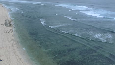 Vista-De-Drones-En-La-Playa-De-Nyang-Nyang-En-Uluwatu-Bali-Indonesia-Con-Olas-Rompiendo-Sobre-Arena-De-Coral-Y-Una-Vasta-Playa-Aislada