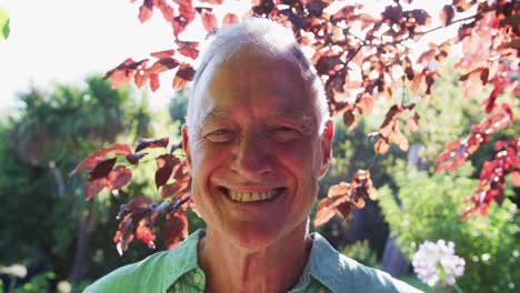 Portrait-of-happy-caucasian-senior-man-in-garden-smiling-in-the-sun