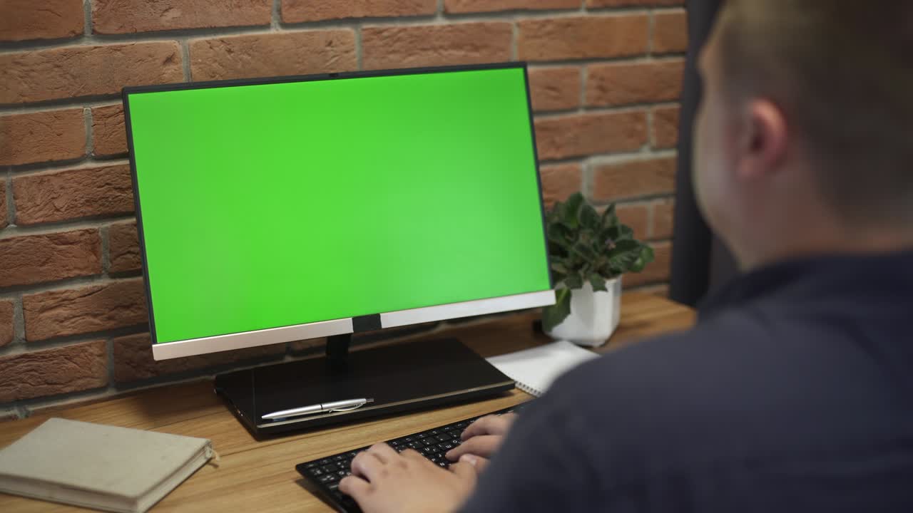 joven trabajando en una computadora con pantalla verde en la oficina. 4k