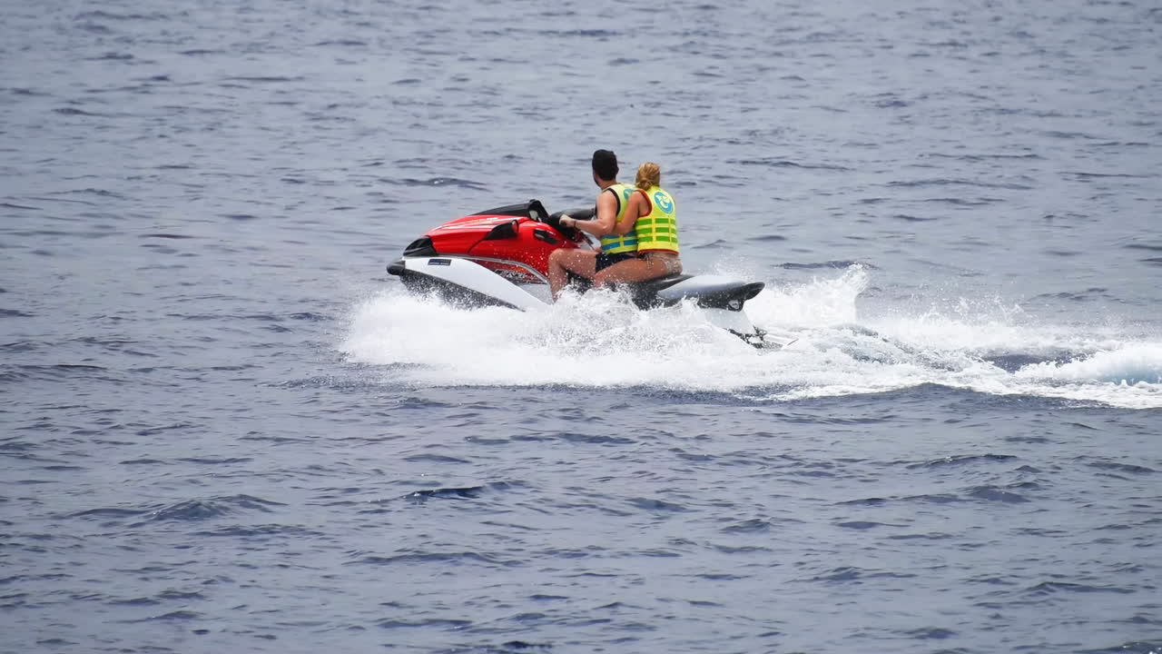 Couple riding a jet ski on the ocean