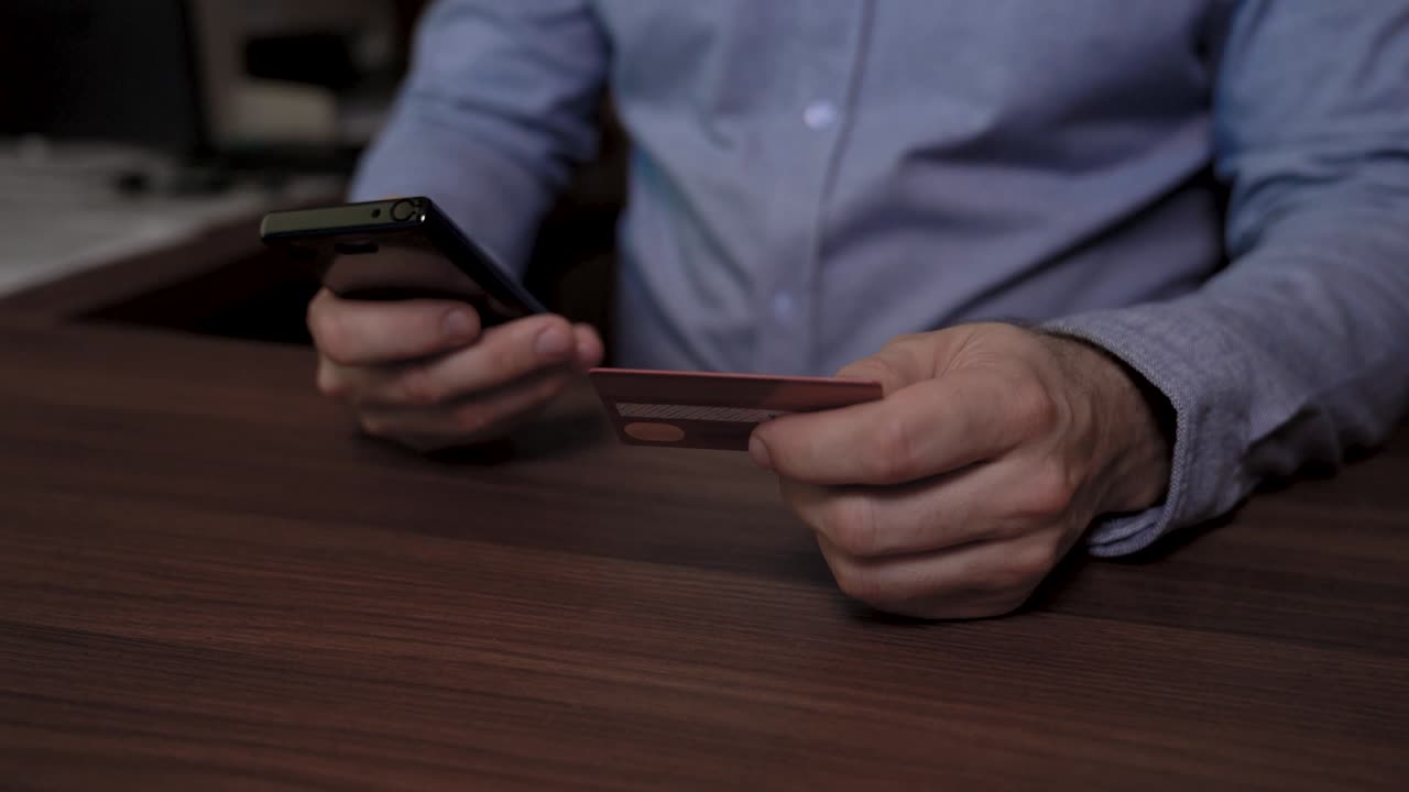 manos de un hombre de negocios con teléfono móvil y tarjeta de crédito. él usa su tarjeta de crédito para pagar en línea. vídeo de imágenes deslizantes.
