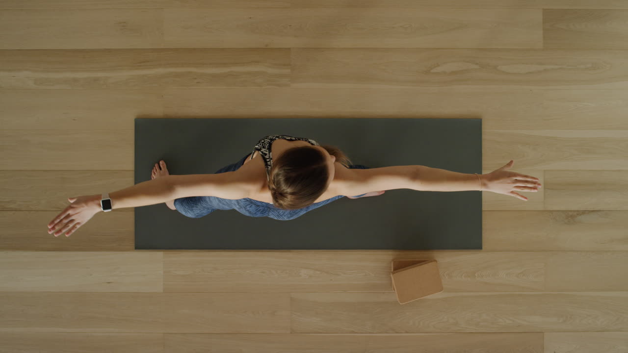 vista superior de una mujer de yoga practicando pose de guerrero en un estudio de ejercicios disfrutando de un estilo de vida saludable, practicando meditación en una colchoneta de ejercicios