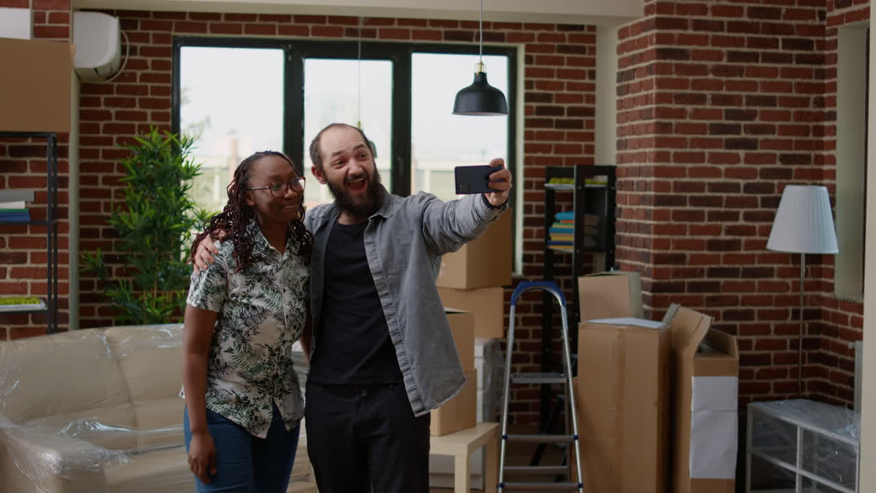 Diverse married couple filming video in new rented household