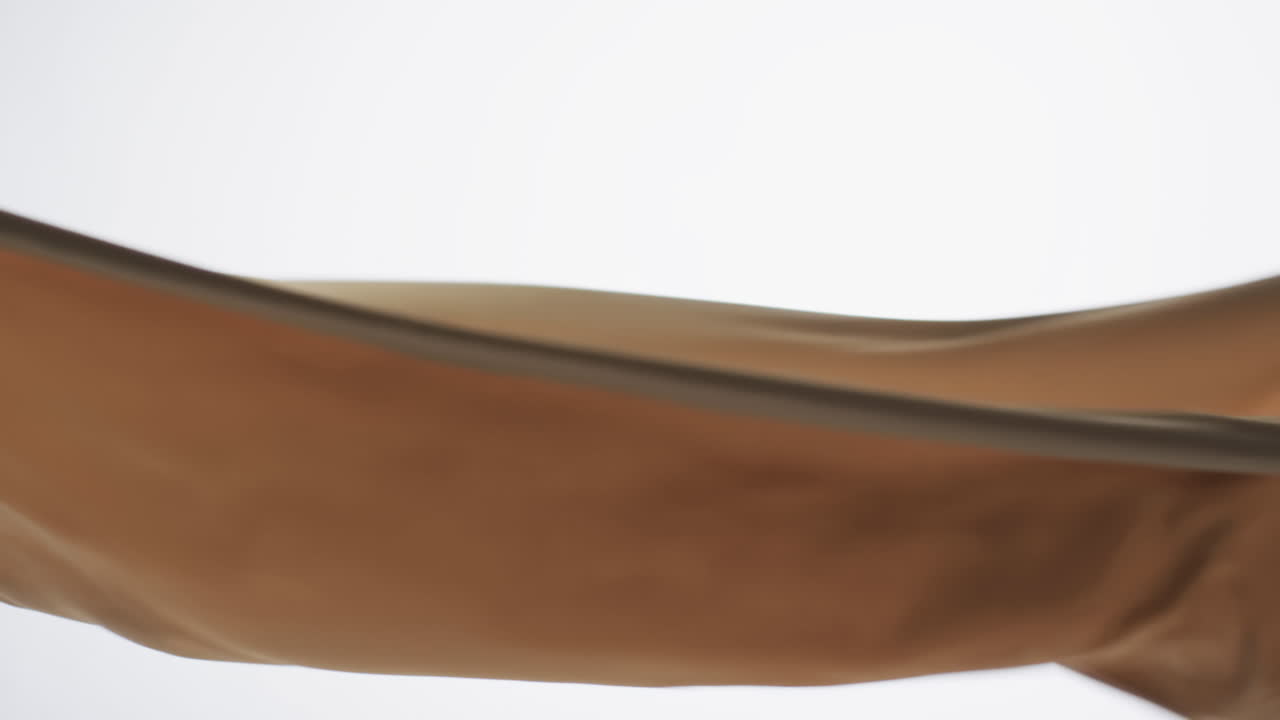 Animation af cremefarvet flagrende stof med plads til tekst på hvid baggrund.
