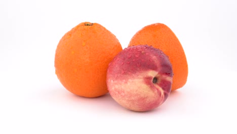 juicy orange fruit, mandarine and nectarine with water drops rotating on white background. isolated. close up.