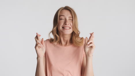 Caucasian-woman-wistfully-crossing-fingers-on-camera.