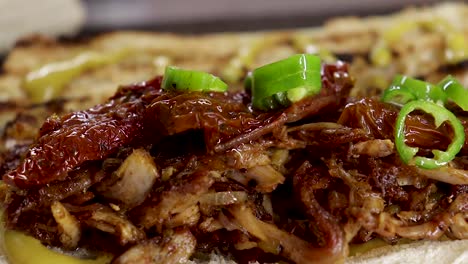 Close-up-of-Green-chillis-on-ripped-chicken-on-a-mini-ciabatta-loaf