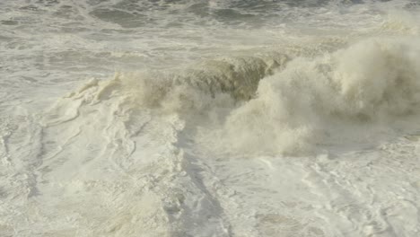 stormy rough sea water, small waves with foam, nazare in portugal high angle view