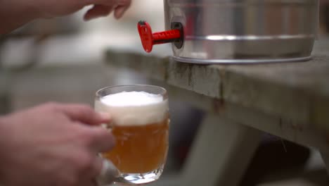 pouring beer from a keg in pub garden