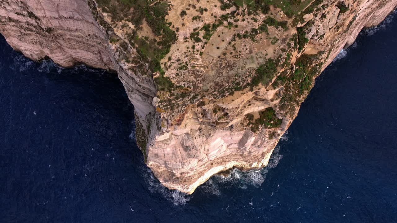 tomada aérea de un avión no tripulado de un acantilado empinado sobre el mar mediterráneo desde los acantilados de dingli en malta