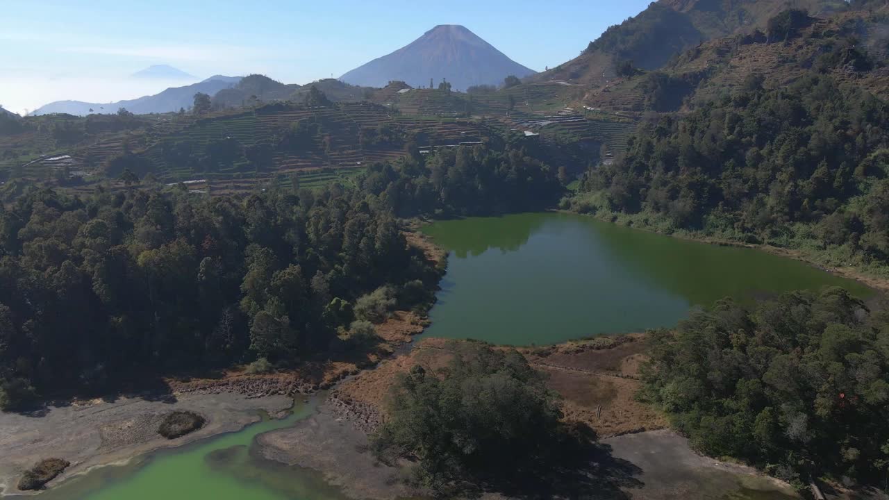 Drone flight over Dieng's Telaga Warna, the color-changing lake in Java, Indonesia