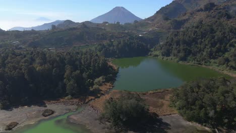 drone flight over dieng's telaga warna, the color-changing lake in java, indonesia