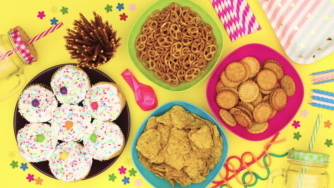 pasteles con crema blanca moviéndose en la mesa con comida de fiesta y decoraciones - detenga el movimiento