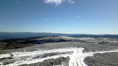 tiro aéreo ascendente volando sobre un camino nevado en un paisaje montañoso en manzaneda, galicia