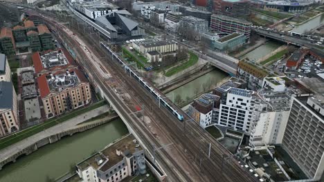 Train-crossing-railway-bridge,-La-Villette,-Paris-in-France