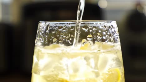 refreshing drink preparation in a kitchen setting with condensation effects on a glass