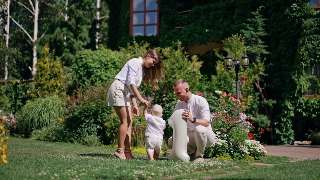 Young Caucasian parents and their little son outdoors. Smiling dad holds a balloon shaped like number one.