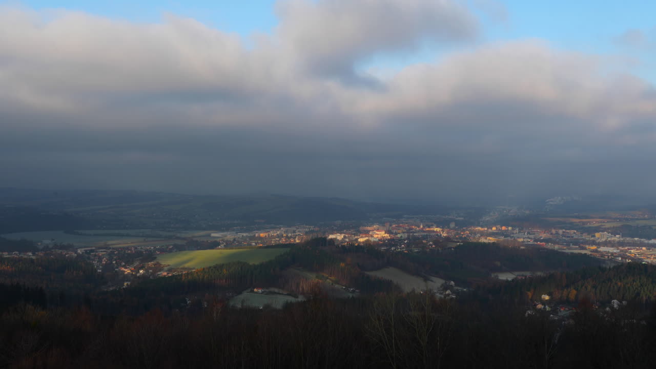 nubes y niebla moviéndose al amanecer sobre la ciudad y los bosques circundantes
